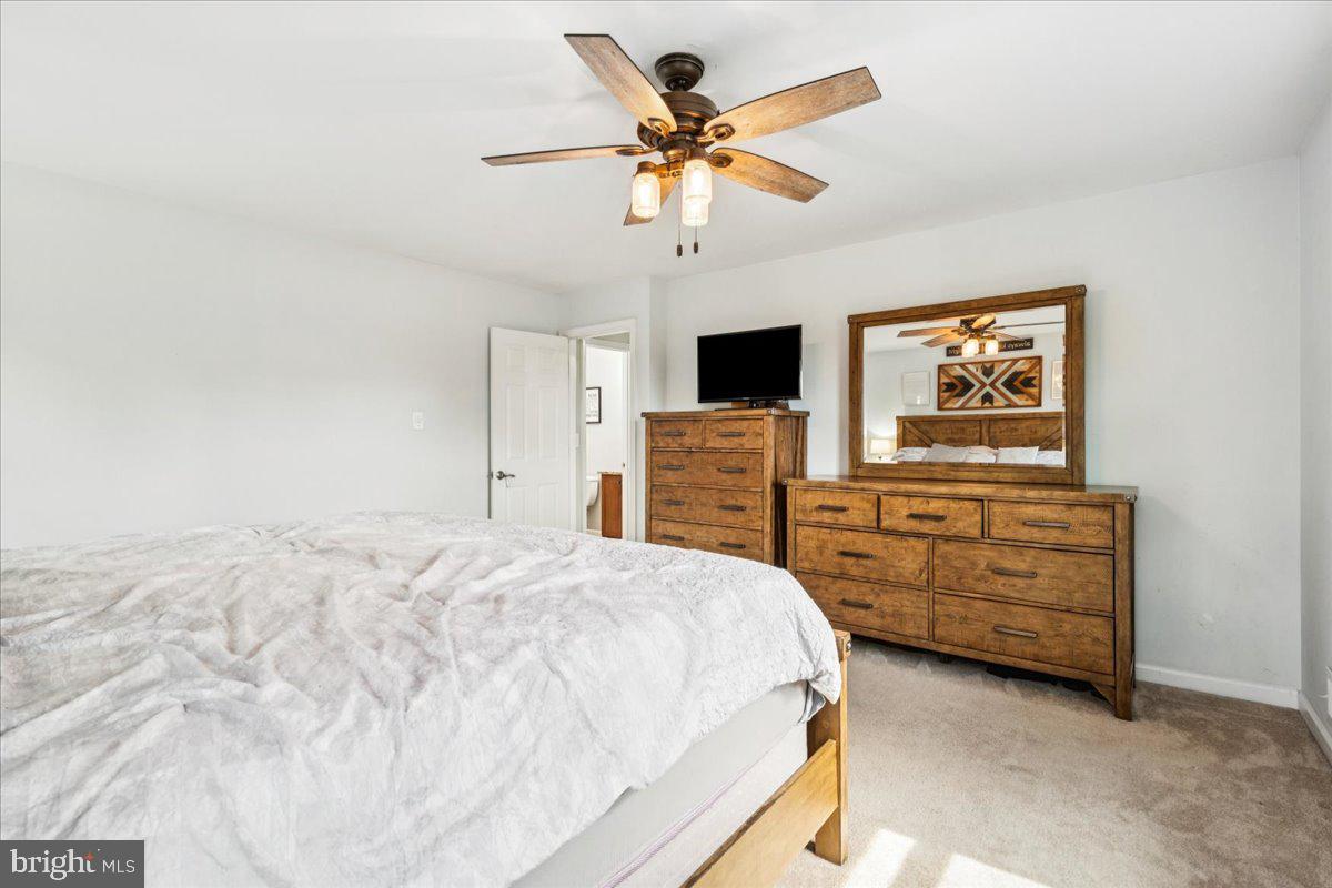 7830 Fingerboard Road Frederick, MD 21704 - Photo 11 of 39 a bedroom with a bed a dresser and a chandelier