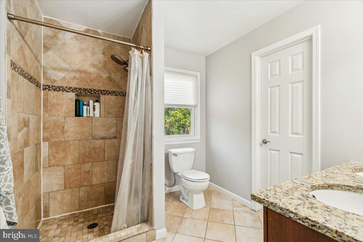 7830 Fingerboard Road Frederick, MD 21704 - Photo 12 of 39 a bathroom with a granite countertop sink toilet and shower