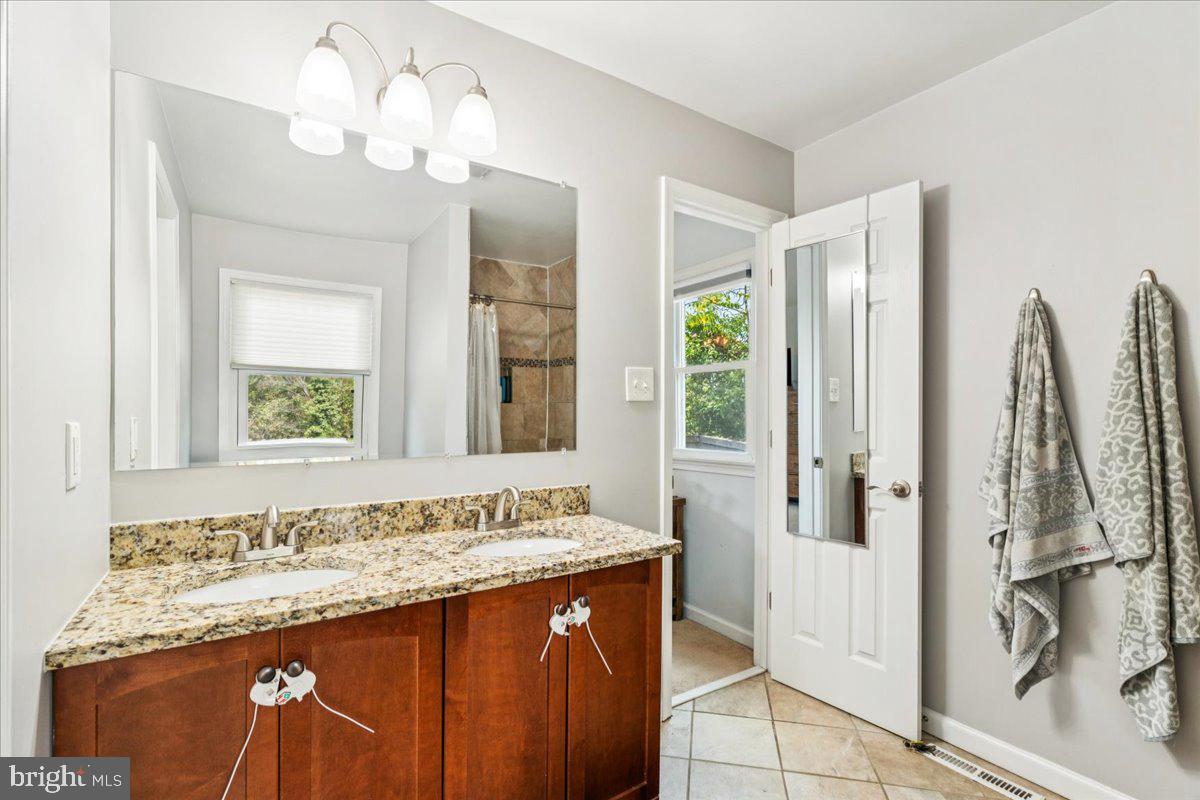 7830 Fingerboard Road Frederick, MD 21704 - Photo 13 of 39 a bathroom with a granite countertop sink a mirror and a shower