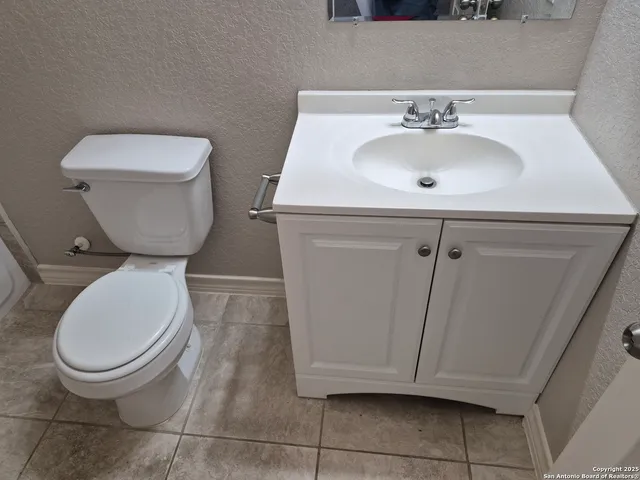 a bathroom with a toilet sink and mirror