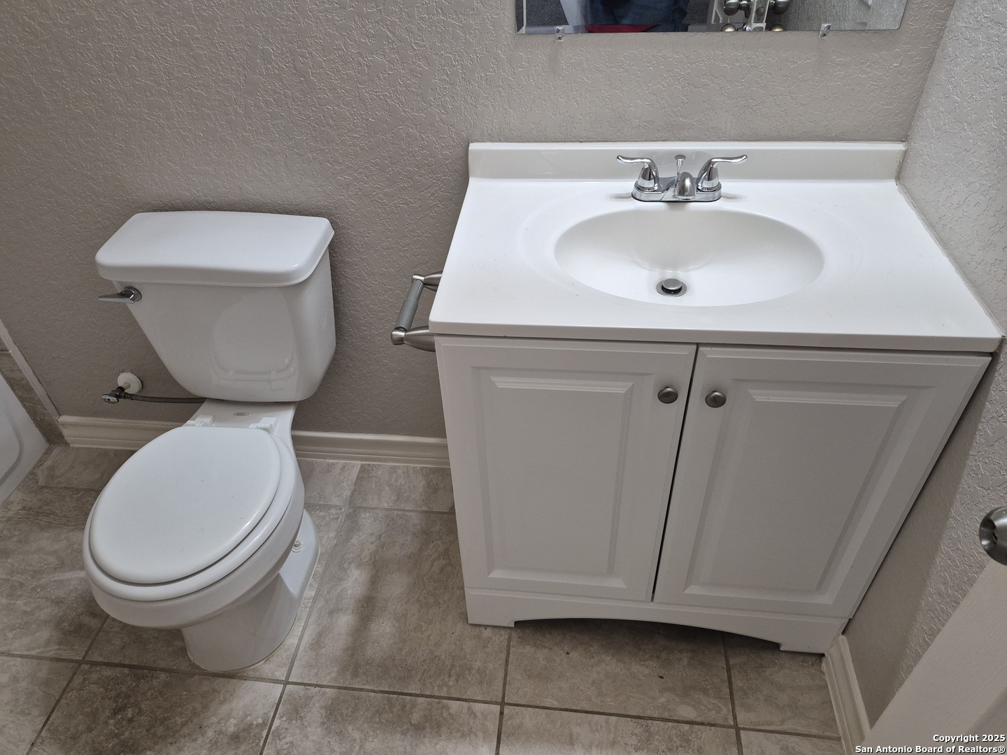 7315 Colina Way, Unit 103 Converse, TX 78109 - Photo 19 of 32 a bathroom with a toilet sink and mirror