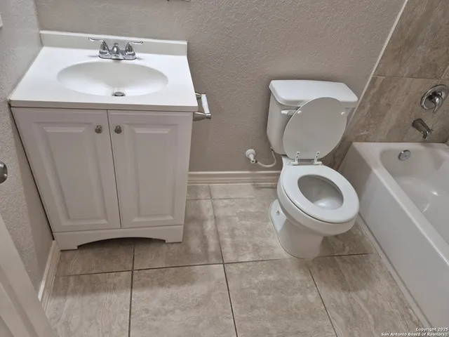 a bathroom with a toilet a sink and mirror