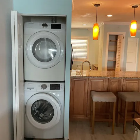 a view of a kitchen with a sink and a washer dryer