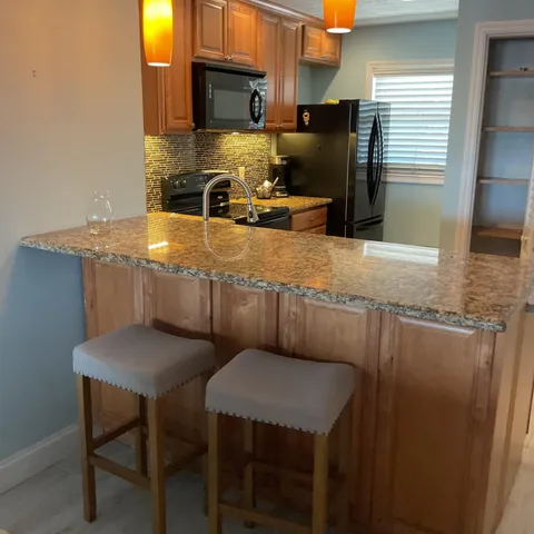 a kitchen with stainless steel appliances granite countertop a sink refrigerator and microwave