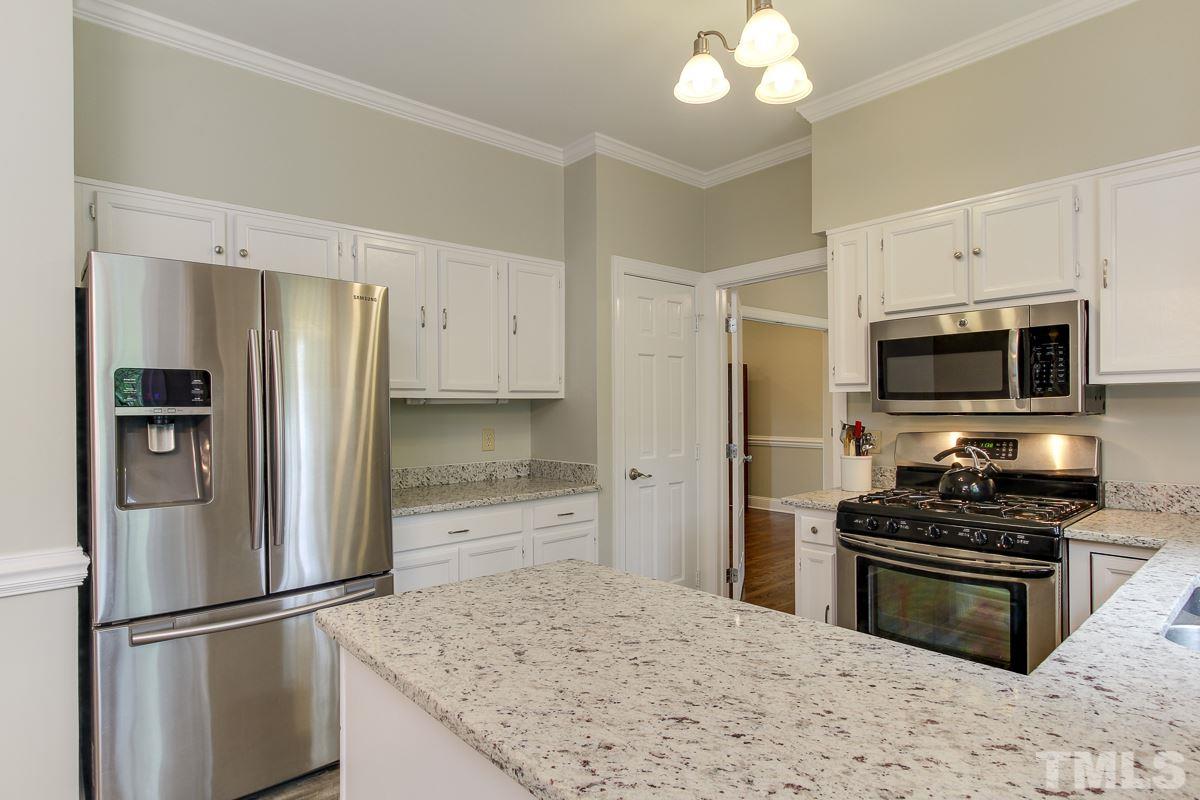 2000 Corberrie Lane Raleigh, NC 27613 - Photo 11 of 25 a kitchen with granite countertop a refrigerator stove and microwave