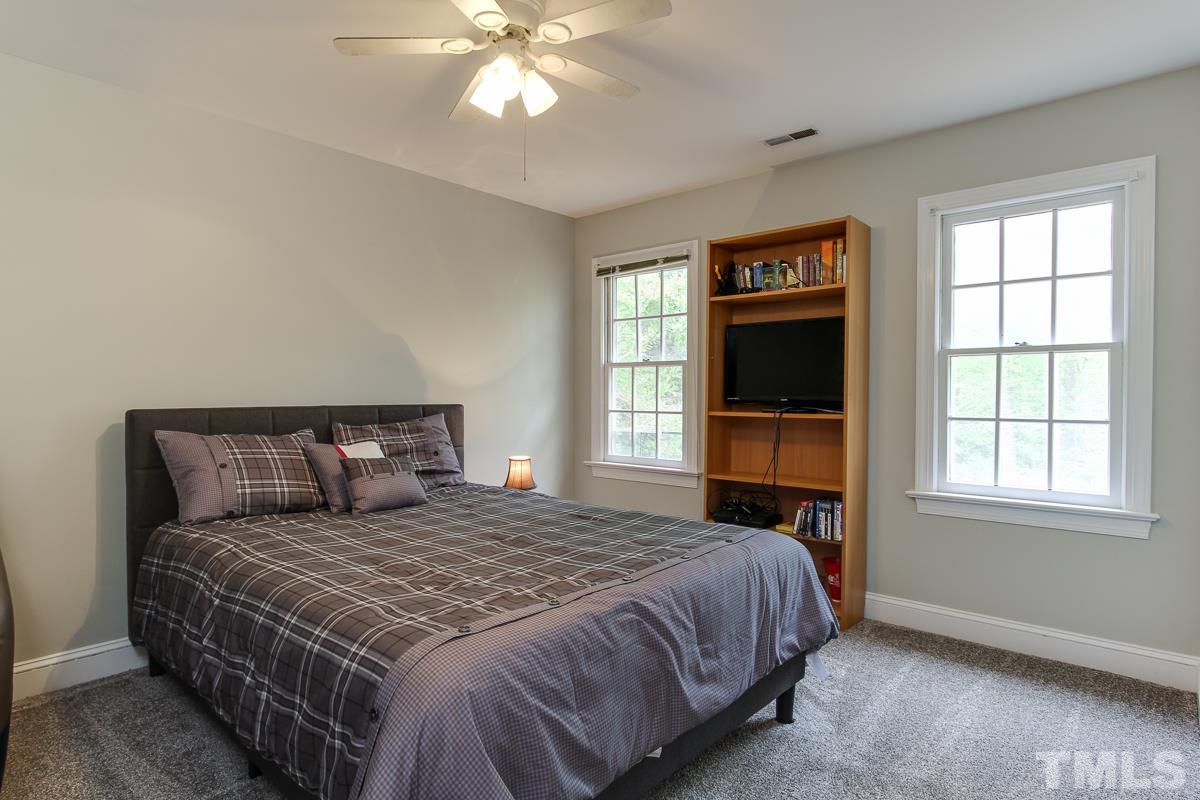 2000 Corberrie Lane Raleigh, NC 27613 - Photo 21 of 25 a bedroom with a large bed and a tv