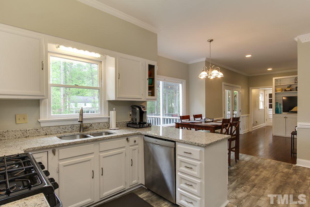 2000 Corberrie Lane Raleigh, NC 27613 - Photo 10 of 25 a kitchen with a stove a sink a center island and cabinets