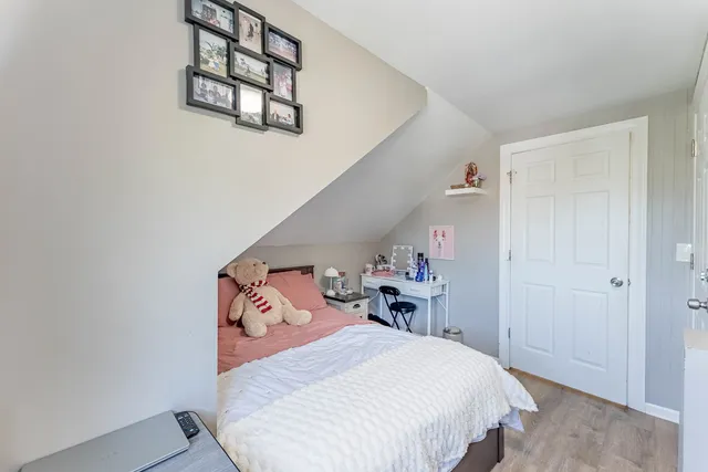 a bedroom with a bed a window and potted plant on a table
