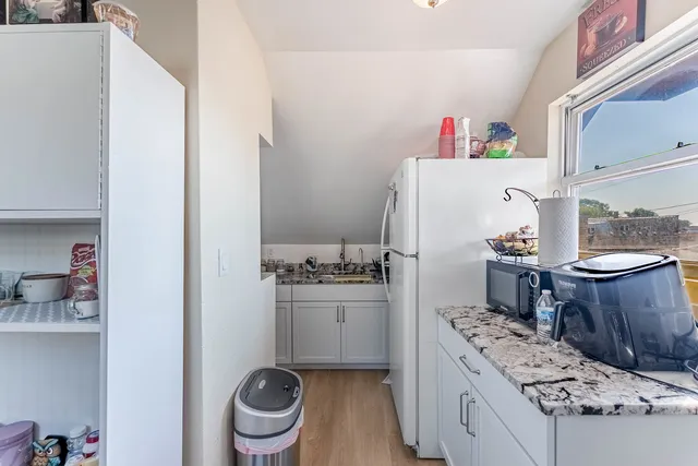a kitchen with a refrigerator and a stove top oven