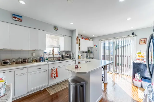 a kitchen with stainless steel appliances a table and chairs in it