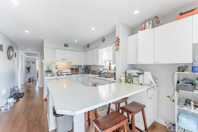 a kitchen with stainless steel appliances a table and chairs