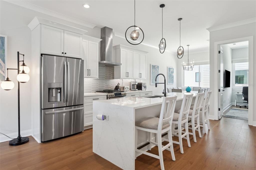 4515 West North A Street, Unit 2 Tampa, FL 33609 - Photo 7 of 21 a kitchen with stainless steel appliances granite countertop a refrigerator a stove a sink dishwasher a dining table and chairs with wooden floor