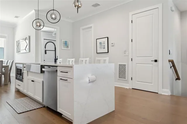 a view of a kitchen with fridge and wooden floor