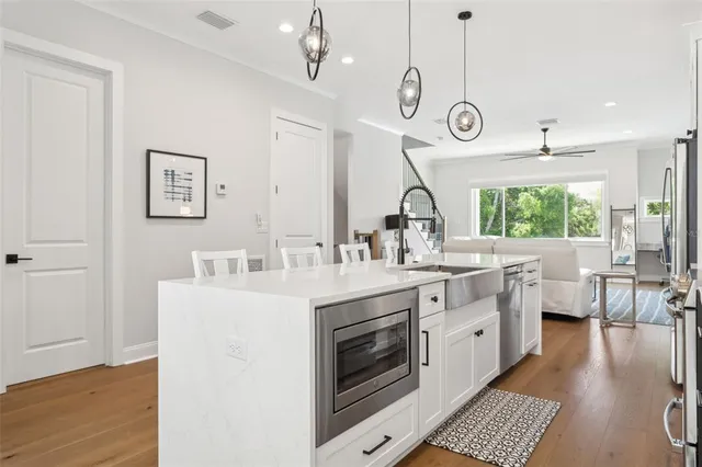 a large kitchen with stainless steel appliances a large center island attached withe living room