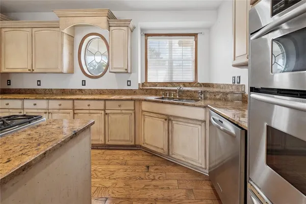 a kitchen with stainless steel appliances granite countertop a stove sink and cabinets
