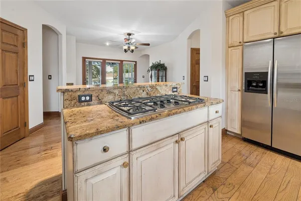 a view of a kitchen with wooden floor electronic appliances and furniture