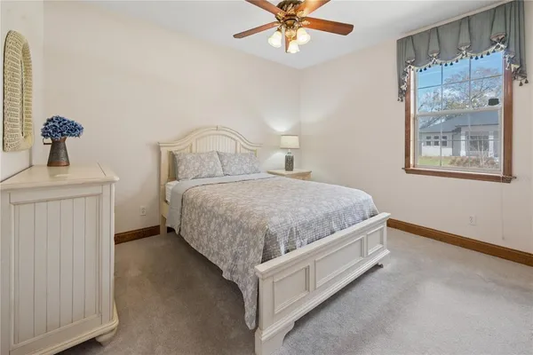 a view of a house with a yard and a large tree