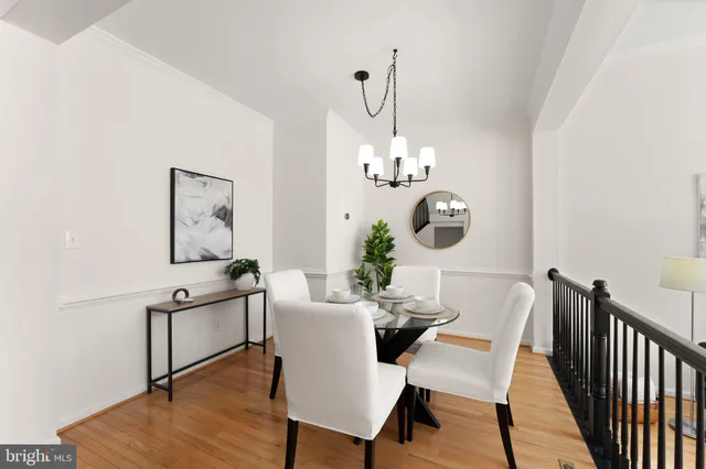 a kitchen with stainless steel appliances a refrigerator a stove a sink dishwasher and white cabinets with wooden floor