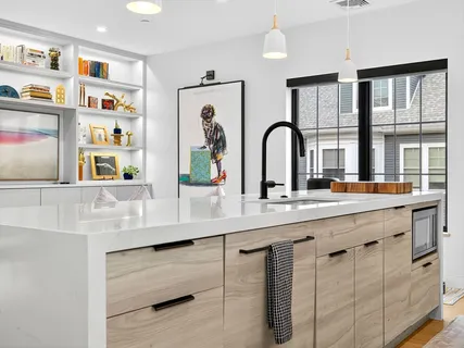 a large white kitchen with stainless steel appliances granite countertop a stove and a sink
