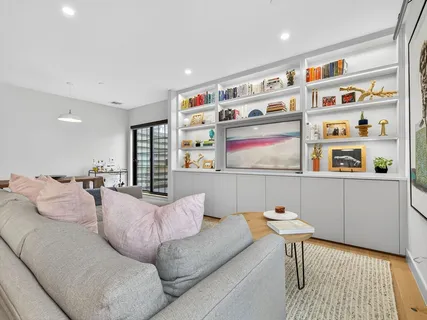 a living room with furniture cabinets and window