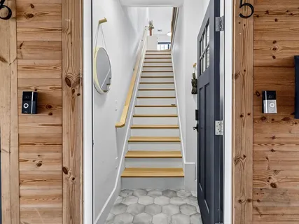 a view of a hallway with wooden floor and entryway