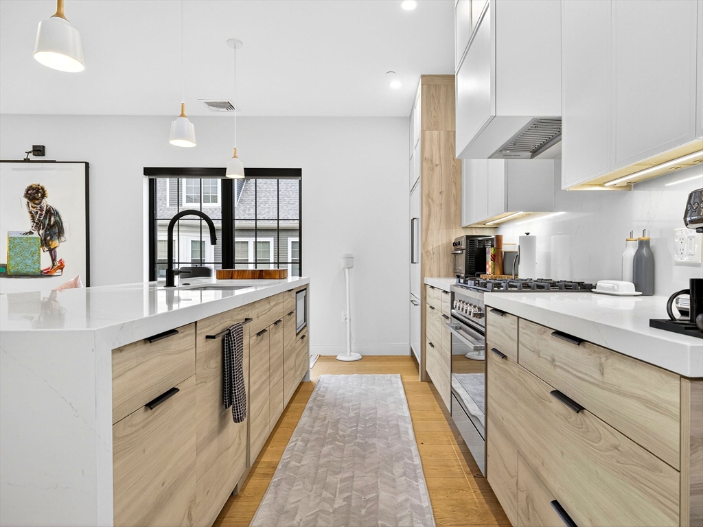 4 Payne Street, Unit 5 Boston, MA 02122 - Photo 9 of 38 a large kitchen with a sink and cabinets