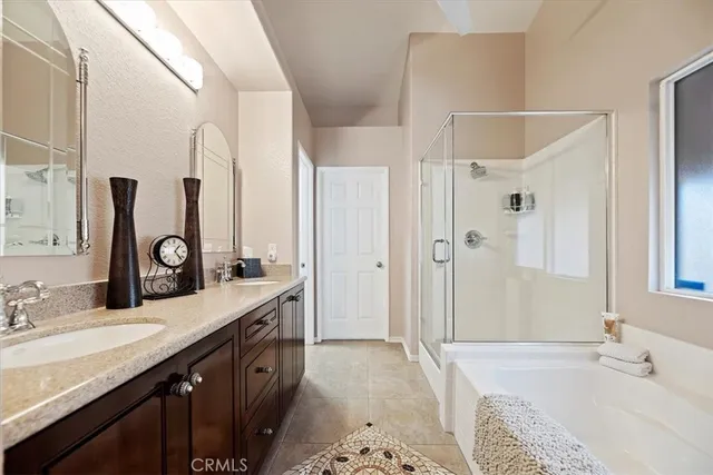 a bathroom with a granite countertop double vanity sink and a mirror