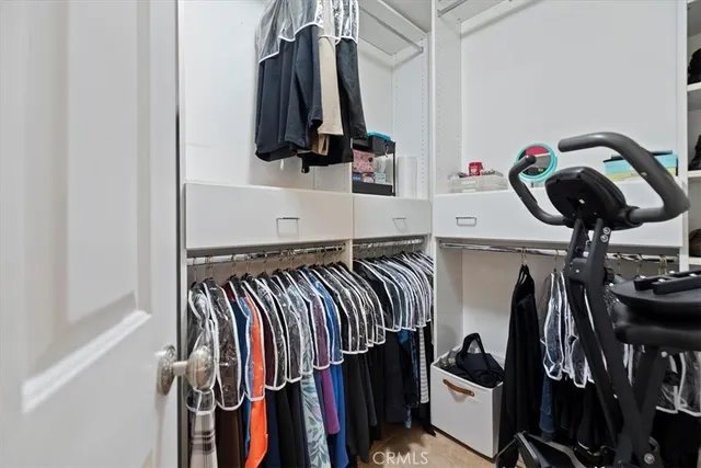 a view of walk in closet with clothes and shoes