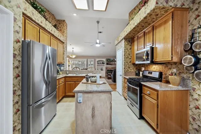 a kitchen with stainless steel appliances granite countertop a refrigerator a stove a sink and dishwasher