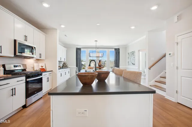 a large kitchen with stainless steel appliances granite countertop a sink a stove and a refrigerator