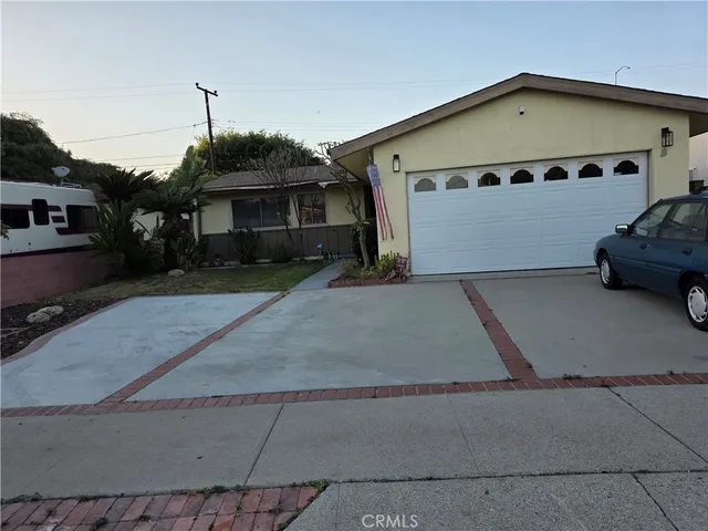 a front view of a house with a garden and parking