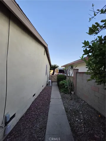 a view of an empty room with wooden floor and a ceiling fan