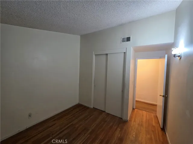 a view of a room with wooden floor and a bathroom