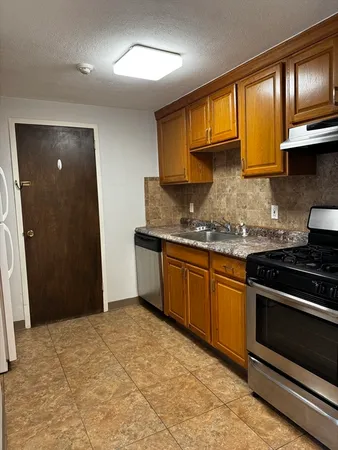 a kitchen with stainless steel appliances granite countertop a stove a sink and a microwave