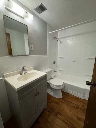 a bathroom with a toilet sink a mirror a bathtub and vanity