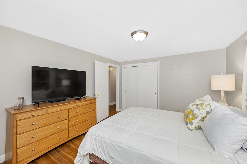 157 Spring Street Stoneham, MA 02180 - Photo 12 of 34 a bedroom with a bed and a flat screen tv