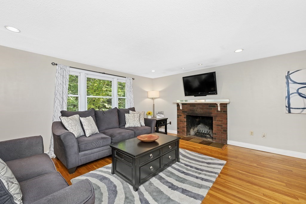 157 Spring Street Stoneham, MA 02180 - Photo 4 of 34 a living room with furniture a fireplace and a flat screen tv