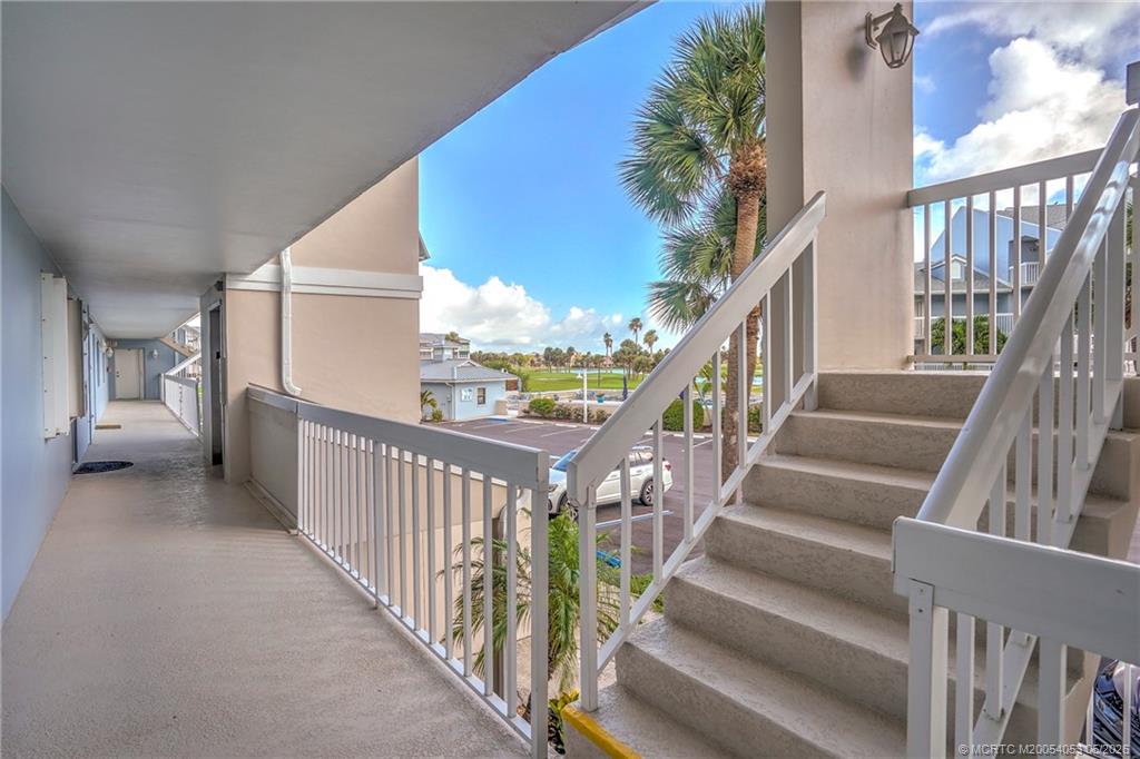 10 Northeast Plantation Road, Unit 101 Jensen Beach, FL 34957 - Photo 5 of 53 a view of staircase with lots of frames on wall and a potted plant