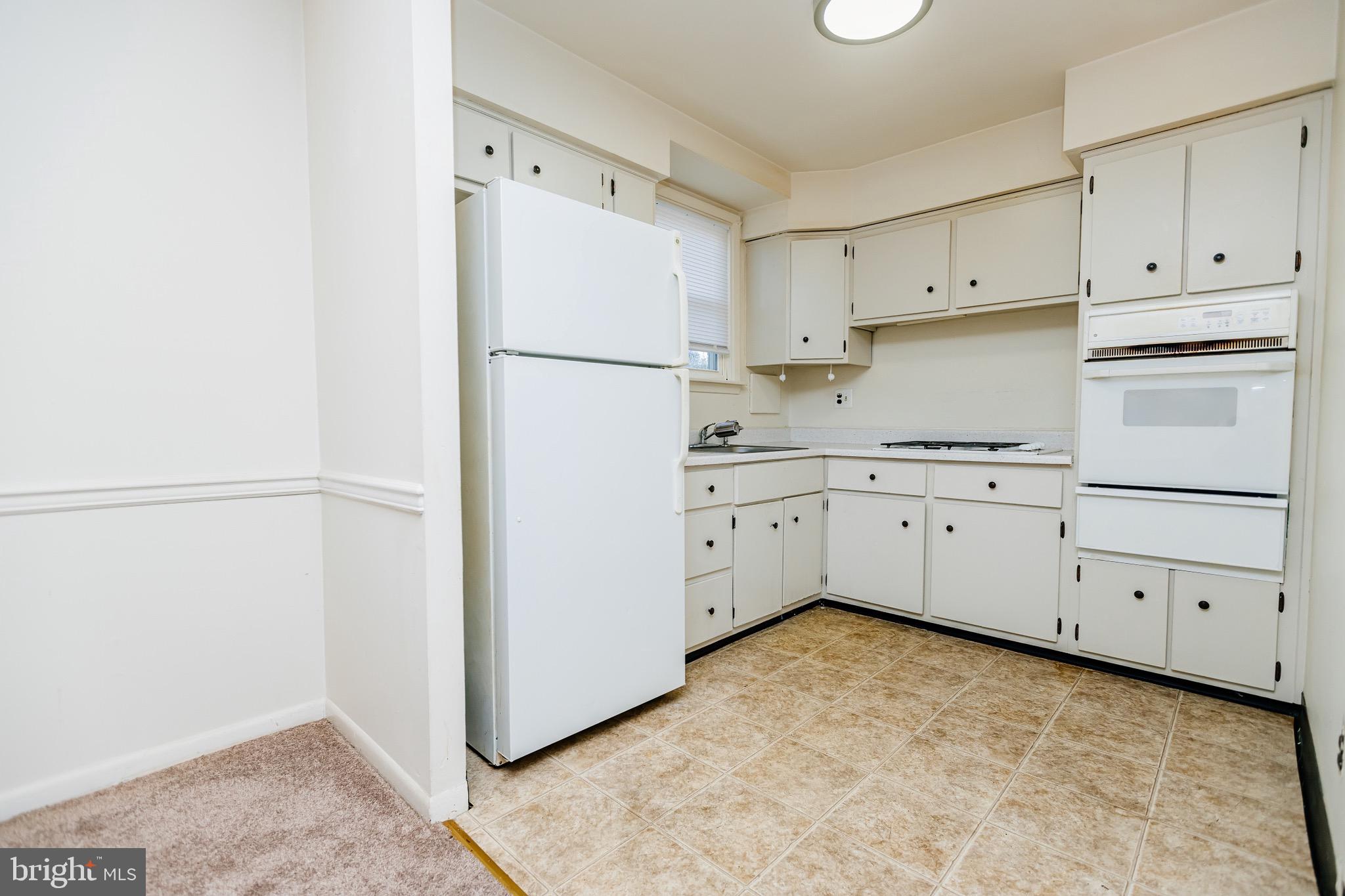 223 Alnus Street Philadelphia, PA 19116 - Photo 3 of 30 a kitchen with white cabinets and white appliances