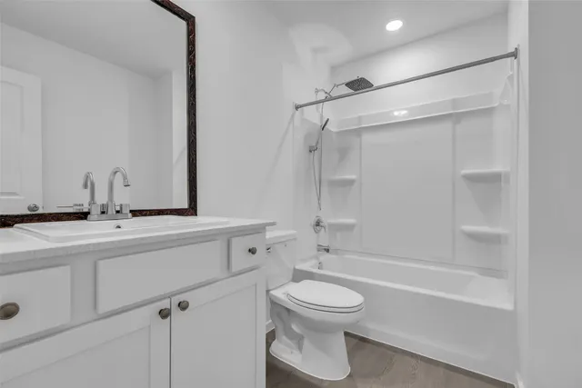 a bathroom with a toilet sink a mirror and shower