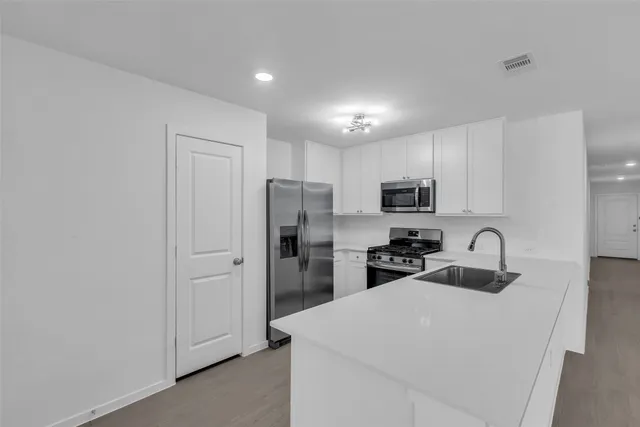 a kitchen with stainless steel appliances a refrigerator sink and microwave