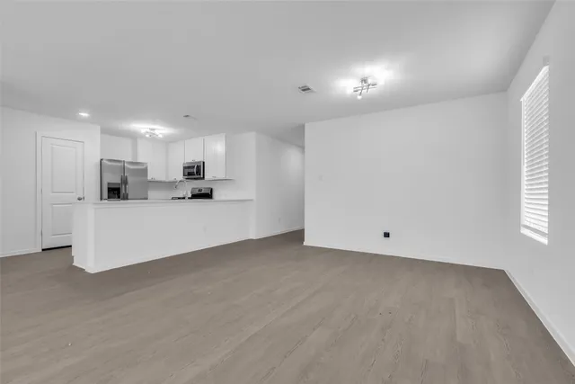 a view of kitchen with refrigerator sink and cabinets