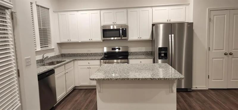 228 Banner Road Pendergrass, GA 30567 - Photo 3 of 8 a kitchen with stainless steel appliances granite countertop a stove refrigerator and microwave