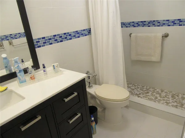 a bathroom with a sink a toilet and mirror