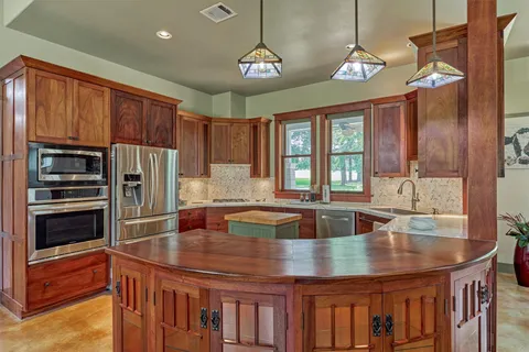 a kitchen with stainless steel appliances granite countertop a sink refrigerator and cabinets