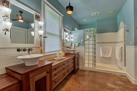 a bathroom with a double vanity sink mirror and shower