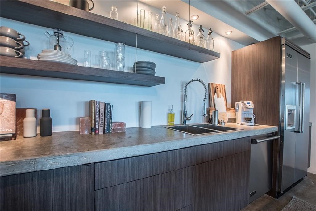 901 North Upper Broadway, Unit 206 Corpus Christi, TX 78401 - Photo 12 of 40 a kitchen with granite countertop a sink stainless steel appliances and cabinets