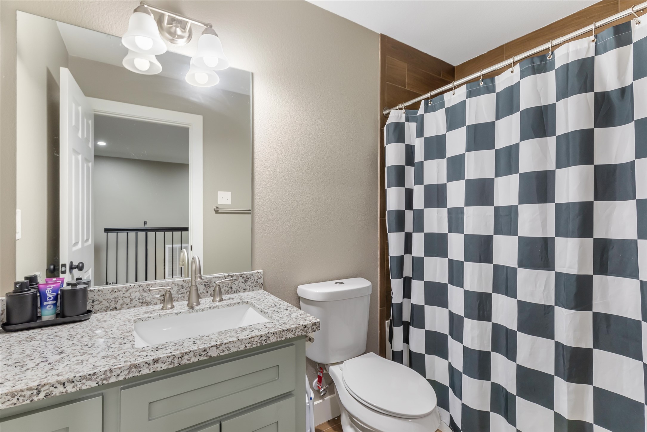 2201 Maple Street Liberty, TX 77575 - Photo 29 of 34 a bathroom with a granite countertop sink a toilet and a mirror