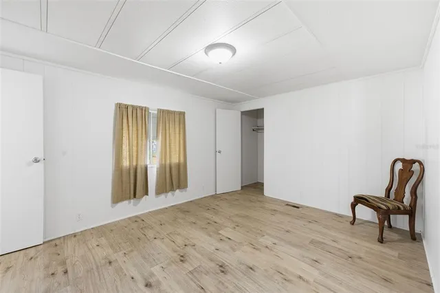 a view of a big room with wooden floor and windows