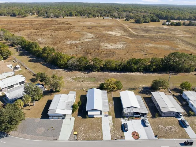 an aerial view of a city with lots of residential buildings ocean and mountain view in back